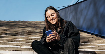 Woman smiling while holding a cellphone