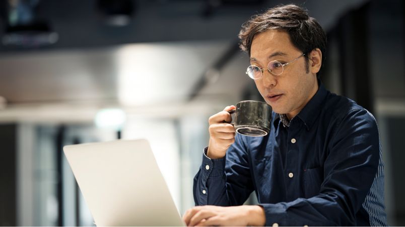 Man looking at the screen of an open notebook